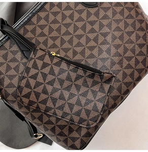 Macro view of geometric pattern tote bag with leather straps and gold metal ring hardware