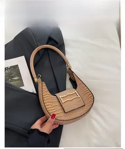 Detailed close-up of khaki crocodile pattern handbag with gold geometric metal buckle