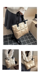Detail of golden quilted tote bag with black nylon handles and soft padded texture