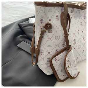 Detail of printed tote bag set with cartoon bear patterns and leather straps