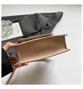 Detail of nude leather shoulder bag with silver buckle on a stylish minimalist background