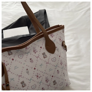 Close-up of printed tote bag featuring cute cartoon bears and brown leather handles