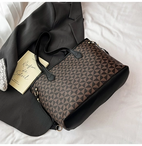 Detail of a large tote bag featuring brown and black geometric patterns and gold ring accents