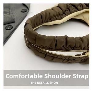 Detail of padded quilted shoulder strap in brown and beige colors with a soft puffy texture