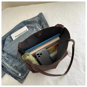 Top view of spacious interior of dark brown tote bag showing daily essentials