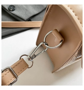 Detailed macro view of the silver metal buckles and sequined side of the beige bag
