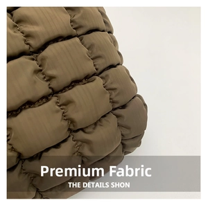Close-up of olive green quilted cloud bag fabric showing thick padded texture