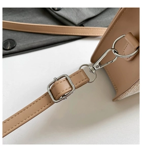 Detail of adjustable leather shoulder strap with silver metal buckle on a sequined handbag