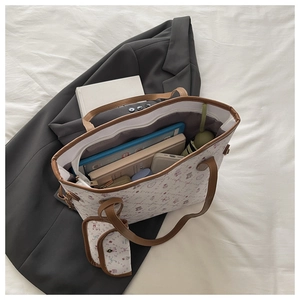 Interior view of spacious white floral tote bag with items and mini coin purse charm