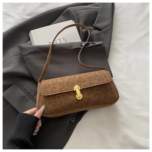 Vue détaillée du sac baguette léopard marron avec boucle dorée sur un blazer gris