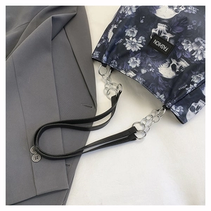 Detail of floral skull print tote bag with leather and silver chain shoulder strap