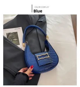 Detail of blue faux crocodile texture crescent bag with golden geometric clasp