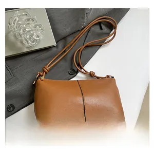 Detailed view of brown lychee leather tote bag featuring a black vertical seam and knotted strap