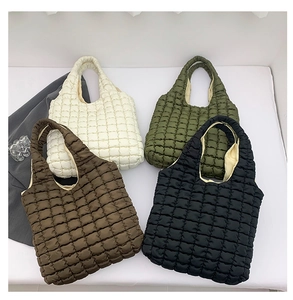 Flat lay of four quilted puffer tote bags in cream, olive, brown, and black colors