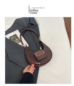 Detail of coffee brown crescent bag with embossed crocodile texture and gold hardware buckle