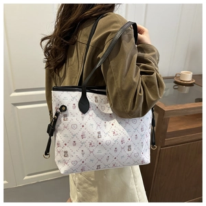 Détail du sac cabas en cuir blanc imprimé avec motifs d'ours et bandoulières noires