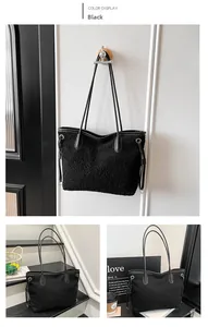 Detail of black faux shearling tote bag with leather straps and gold metal rivets