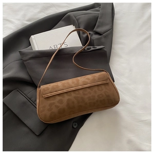 Detail der modischen Baguette-Tasche mit Leopardenmuster auf einem grauen Blazer