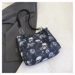 Close-up of Gothic skull and floral print tote bag with silver chain handles and leather strap