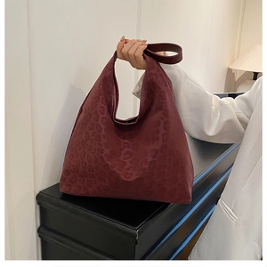 Close-up of wine red leopard print tote bag showing matte texture and wide handle