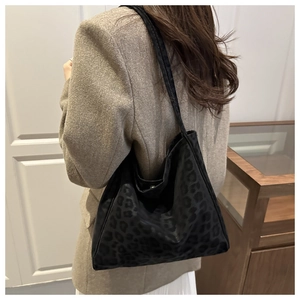 Detail of large black leopard print tote bag styled with a winter wool blazer