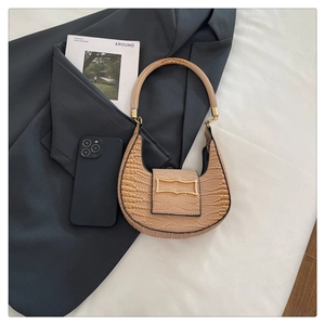 Detail of light brown crescent bag with faux crocodile pattern and vintage gold buckle