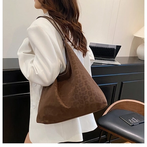 Detail of dark brown leopard pattern tote bag in soft suede fabric for office commute