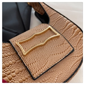 Close-up of tan snakeskin embossed leather with a unique golden geometric buckle
