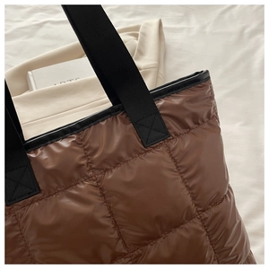Gros plan du sac fourre-tout matelassé marron avec détails de sangles en toile