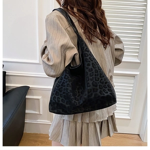 Detail of hobo shoulder bag featuring leopard print on soft suede texture with leather strap