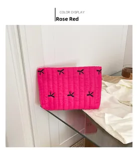Close-up of rose red quilted pouch with embroidered butterfly pattern on smooth fabric