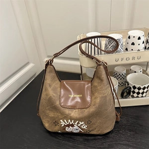 Borsa a tracolla in tela marrone vintage con patta in pelle e tracolla regolabile in scena