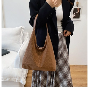 Brown leopard print hobo bag worn by a model in a stylish indoor lifestyle setting