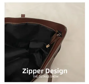 Detail showing the internal zipper pocket and black fabric lining of brown tote bag