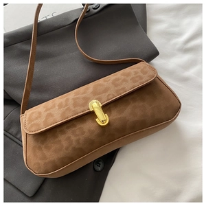 Détail du sac baguette en daim à motif léopard avec fermoir en métal doré élégant