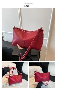 Detail of a dark red lychee grain leather bag featuring unique knotted strap with metal tips