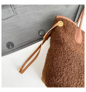 Détail d'un sac cabas marron en peluche avec bandoulière en cuir et œillets dorés