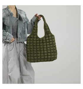 Detail view of army green quilted puffer tote bag with square stitched texture