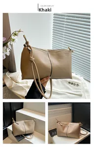 Macro detail of khaki lychee grain leather handbag with gold zipper and stitching