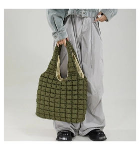 Close-up of olive green quilted tote bag showing soft padded texture and puffy handle