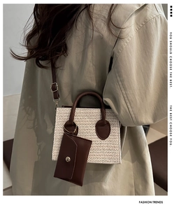 Detail of woven straw crossbody bag with brown leather straps and a detachable small pouch
