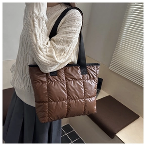 Brown quilted puffer tote bag shown on shoulder for daily commute lifestyle