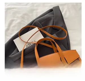 Detail showing the brown monogram canvas texture with orange leather trim and metal clasp