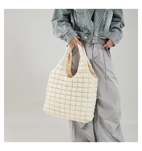 Detail of cream quilted tote bag showing thick puffer texture and bubble lattice pattern