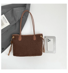 Détail du sac cabas en peau lainée marron avec poignées en cuir et une tablette