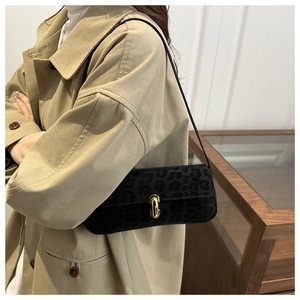 Détail de la texture léopard noire en fausse fourrure et boucle dorée du sac à main