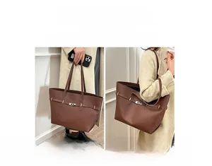 Macro detail of brown tote bag showing gold twist lock and versatile shoulder strap use