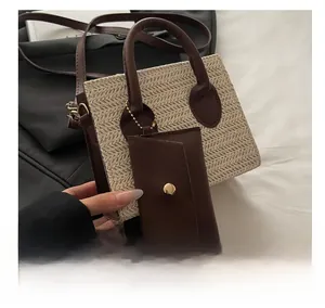 Detail of straw woven tote bag with dark brown leather handles and a matching mini pouch