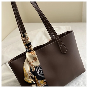 Detail of dark brown tote bag with white contrast stitching and decorative printed scarf