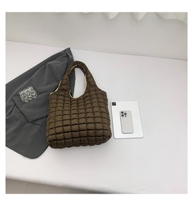 Detailed view of brown quilted puffer tote bag with a soft texture and lattice pattern